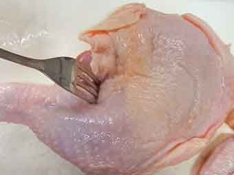 骨付き鶏もも肉にフォークで穴あけ