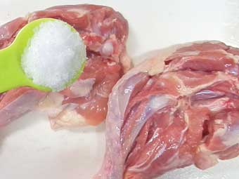 骨付き鶏もも肉に塩を振る