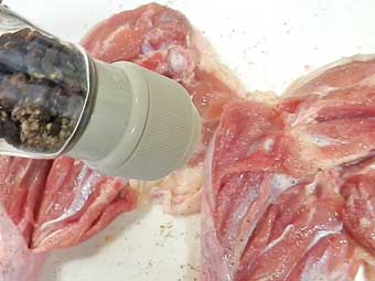 骨付き鶏もも肉に胡椒を振る