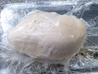 カオマンガイ用の茹で鶏をラップで包む