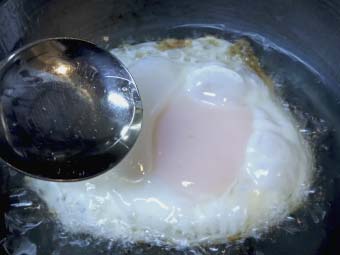 卵の表面にスプーンで油をかける