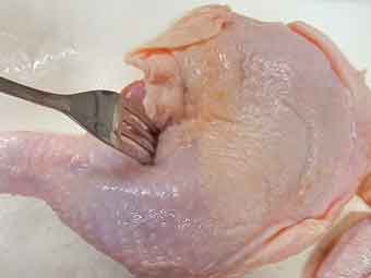 骨付き鶏もも肉にフォークで穴をあける